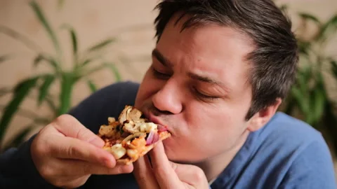 A nice guy with great pleasure eats a delicious vegetarian pizza Stock-Footage 149315444