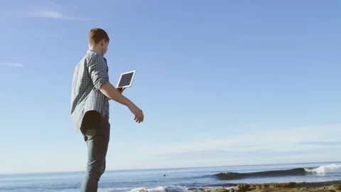 Nice guy in having a video chat on a coast Stock Footage 75755804