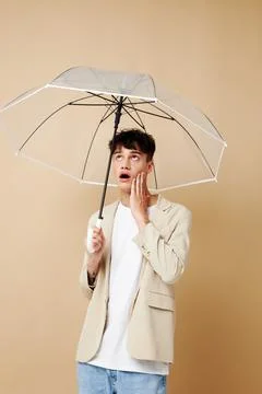 Nice guy in a jacket with an open umbrella protection from the rain Stock Photos