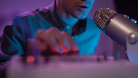 Nice guy mimics the drumming holding pen and listening music synthesizer Stock Footage 127582427