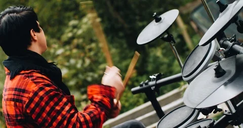 Nice guy plays on the electronic drum in nature. Side view. Close up. Stock Footage 114519978