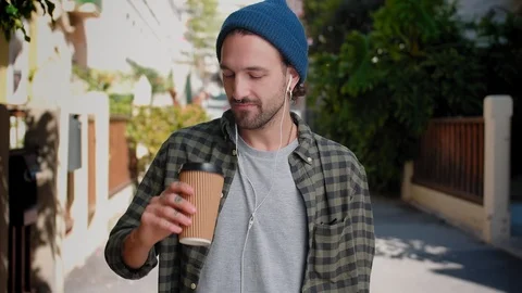 Nice Hispanic trendy guy enjoying tasty drink and smiling to camera at calm city Stock Footage 111071110