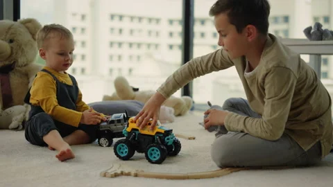 Nice kids sharing toy cars on carpet. Amazing kids playing together indoors. Stock Footage