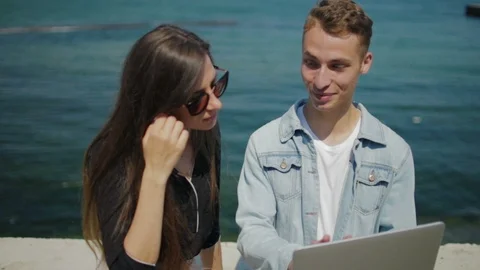 Nice lady and blonde guy sit on parapet with notebook 스톡 동영상 112189729