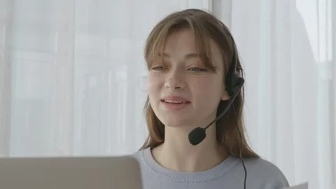 A nice lady smiles as she talks into her headset on a call Stock Footage 263701669
