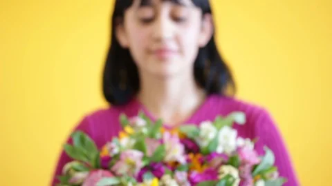 Nice latin lady presenting gorgeous bouquet, yellow flashy background Stock-Footage 124664071