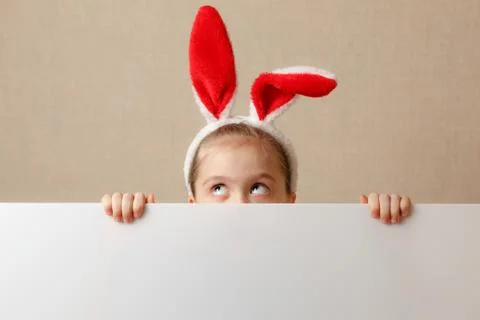 A nice little girl is looking because of an empty banner in which you can ins Stock Photos