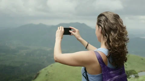 Nice long haired backpacker girl taking photo with smartphone in india mountains Stock Footage 59680780