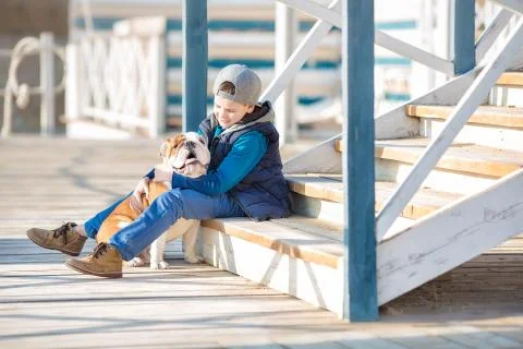 Nice looking handsome boy on beach with bulldog Stock Photos