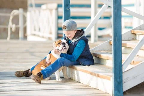 Nice looking handsome boy on beach with bulldog Stock Photos