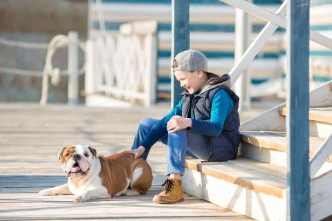 Nice looking handsome boy on beach with bulldog Stock Photos
