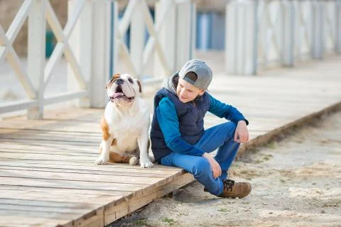 Nice looking handsome boy on beach with bulldog Stock-Fotos