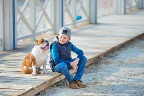 Nice looking handsome boy on beach with bulldog Stock-Fotos