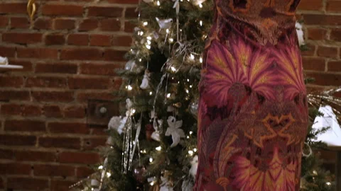 Nice-looking lady is decorating the tree Stock Footage 85883194