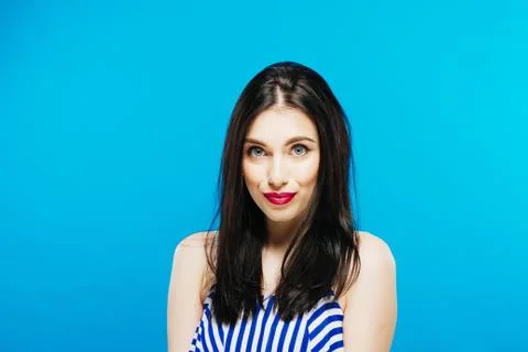 Nice-looking Model in Striped Summer Dress Posing in Studio on Blue Background 스톡 사진