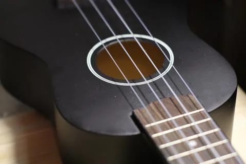 Nice looking neck of a small black guitar Stock Photos