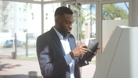 Nice-looking successful businessman taking money from credit card using an ATM Stock Footage 110470420