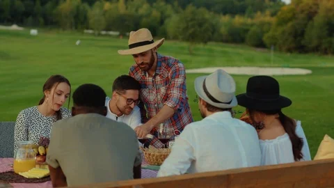 Nice-looking young friends eating and tasting wine on dinner picnic outdoor Stock Footage 117257089