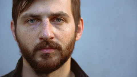 Nice man looks directly at camera on gray background. Portrait of guy outdoor Video stock 129979212