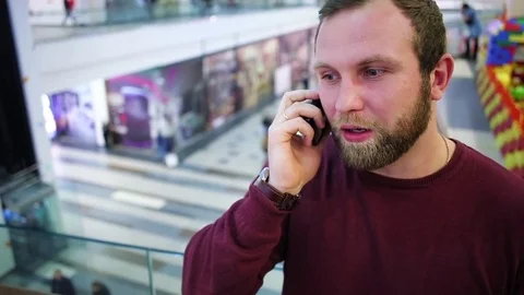 Nice man talking on the phone in shopping Mall Stock Footage 73993973