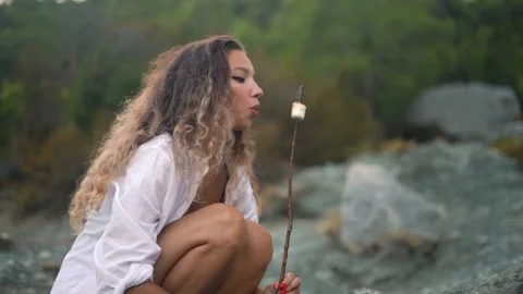 Nice model holds and blows on wooden stick with marshmallow Video stock 143341559