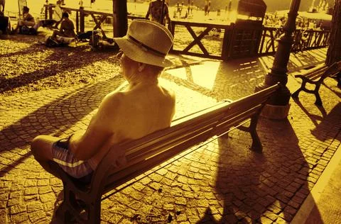 Nice old man sitting in front of the beach Stock Photos