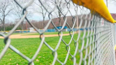 NICE IN&amp;OUT FOCUS OF BASEBALL FIELD THROUGH SIDELINE FENCE Stock Footage 182480650