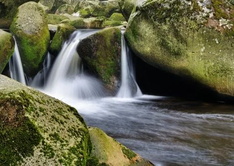 Nice peaceful cascade between mossy rocks and stones Stock Photos
