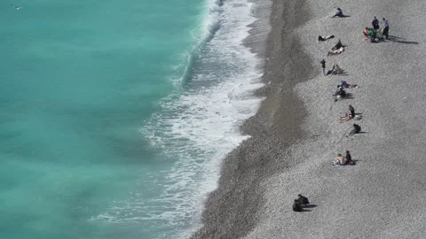 Nice Pebble Beach - Sunbathing People on Shoreline. Stock Footage 329585575
