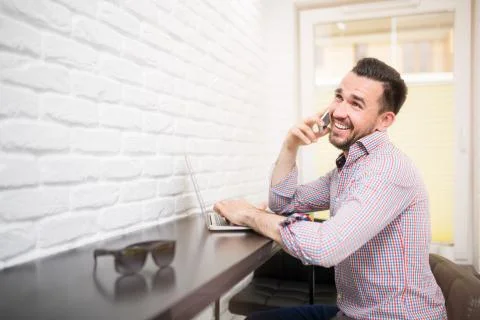 Nice phone conversation while answering e-mails in kitchen Stock Photos