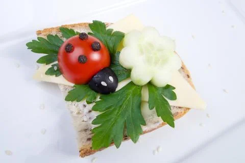Nice red lady-bird on bread with vegetable on wooden board with napkin Stock Photos