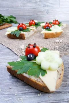 Nice red lady-bird on bread with vegetable on wooden board with napkin Stock Photos