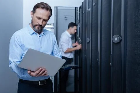 Nice serious programmer looking at the laptop screen Stock Photos