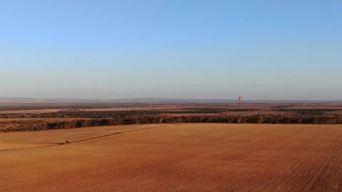 Nice shot of paramotor flying over the wide crop field Video stock 116565750