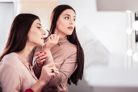 Nice skilled makeup artist using a brow pencil Foto stock