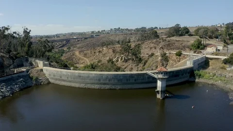 Nice slow and low flyover of a curved concrete arch-gravity reservoir dam Stock Footage 120383035