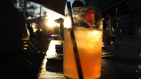Nice summer drink during sunset with guy taking his bear Stock Footage 90487265