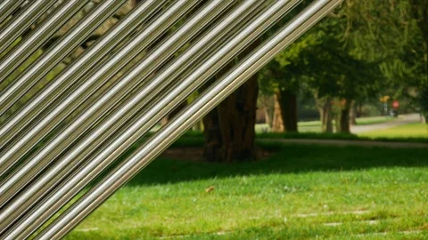 A nice sunny part of forest is behind an abstract patterned metal installation Stock-Footage 105293034