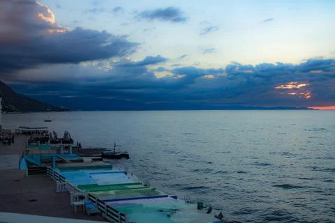 Nice sunset behind the clouds with the beach line Stock Photos