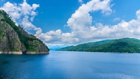 Nice time lapse video with blue lake water, hight rock mountain and nice clouds. Stock Footage 123076404