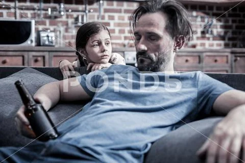 Nice unhappy girl standing behind the sofa Stock Photos