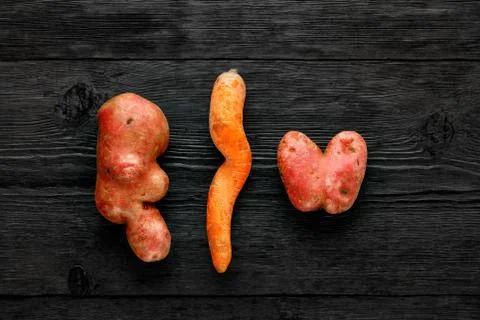 Nice vegetables. Two potatoes of a strange ugly shape and twisted carrots on  Stock Photos