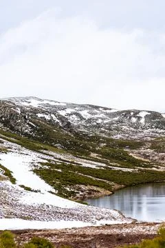 Nice vertical panoramic view of a lagoon with snowy mountains in the backgrou Stock Photos