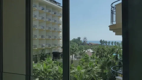 Nice view from the hotel window on the sea, palm trees. The girl takes a photo Stock Footage 80326359