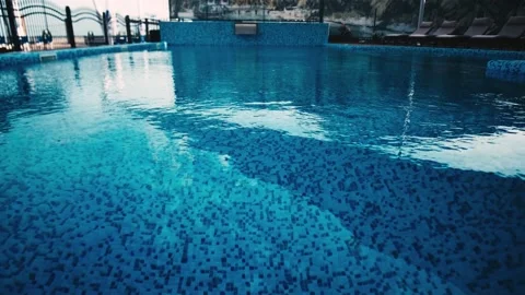Nice view of the outdoor pool with clear blue water. Sun loungers at the edge of Stock Footage 137779373