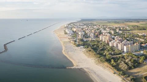 Nice view of sandy beach with umbrellas adriatic sea and town Photos