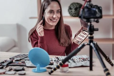 Nice visagiste sitting at the table in front of camera Foto stock
