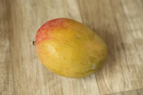 Nice yellow fresh raw mango on wood table Stock Photos