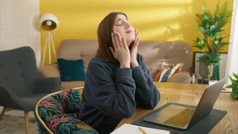 Nice young brunette going crazy, grabbing her head, while working on laptop Stock Footage 245838415