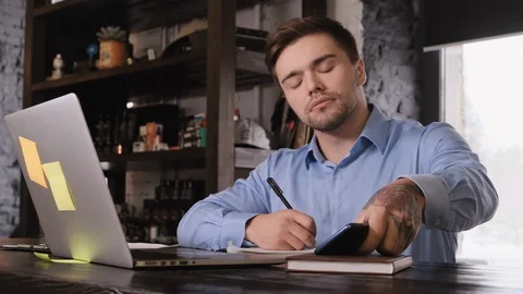 Nice young businessman answer the call while working Stock Footage 104137249